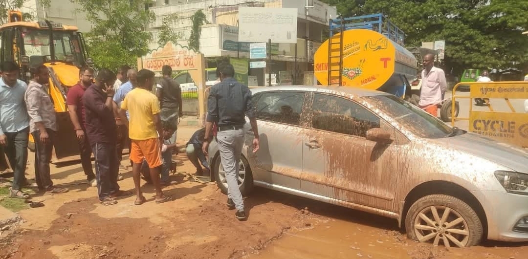 ಪೂರ್ಣಗೊಳ್ಳದ ರಸ್ತೆ ಕಾಮಗಾರಿ, ಗುಂಡಿಯಲ್ಲಿ ಸಿಲುಕಿದ ಕಾರಿನ ಚಕ್ರ! - News Karnataka
